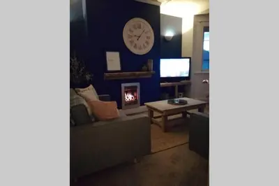 a living room with a couch and a clock on the wall at Unique 2 Bedroom Apartment in the Ideal Location in Blackpool