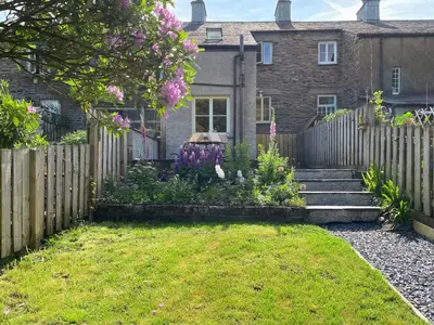 a garden in front of a house with a fence at The Burrow in Haverthwaite