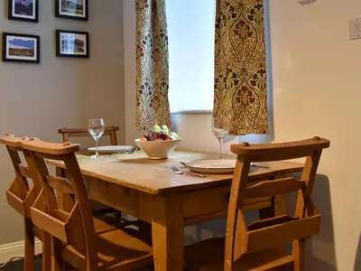 a dining room table with two chairs and a window at The Burrow in Haverthwaite