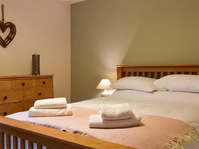 a bedroom with a bed with two towels on it at The Burrow in Haverthwaite