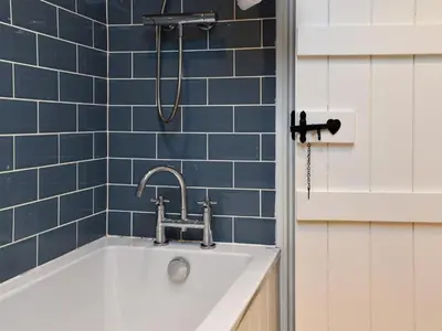 a bathroom with a white sink and blue tiles at The Burrow in Haverthwaite