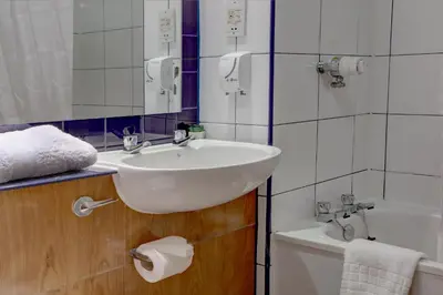 a bathroom with a sink and a toilet and a tub at Plaza Hotel, Preston Lancashire, Sure Collection by Best Western in Chorley