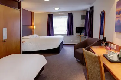 a hotel room with two beds and a couch and a table at Plaza Hotel, Preston Lancashire, Sure Collection by Best Western in Chorley