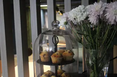 a glass display with muffins and a vase of flowers at Plaza Hotel, Preston Lancashire, Sure Collection by Best Western in Chorley