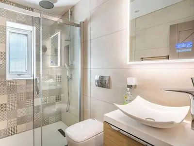 a bathroom with a sink and a shower and a toilet at Beeches Cottage in Blackburn