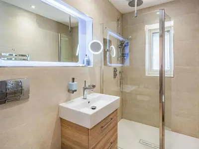 a bathroom with a sink and a shower at Beeches Cottage in Blackburn