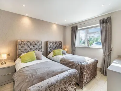 a bedroom with two beds and a window at Beeches Cottage in Blackburn