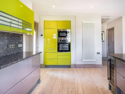 a kitchen with yellow cabinets and a yellow door at Beeches Cottage in Blackburn