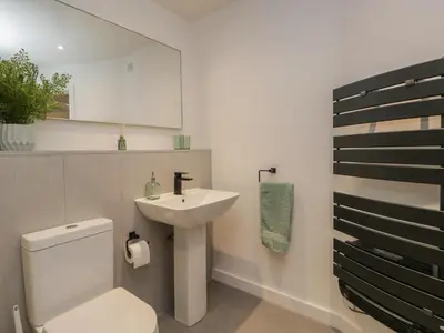 a bathroom with a white toilet and a sink at Woodland Lodge in Grange Over Sands