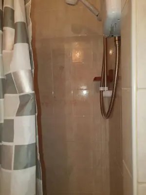 a shower in a bathroom with a shower curtain at The Rutlands in Blackpool