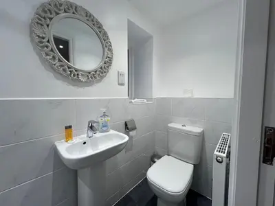 a bathroom with a toilet and a sink and a mirror at Innkeepers Cottage in Ulverston
