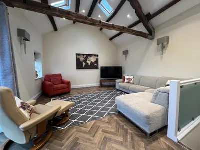 a living room with couches and a tv at Innkeepers Cottage in Ulverston