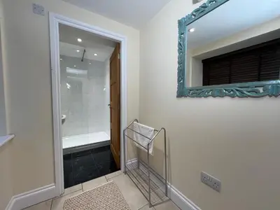 a bathroom with a mirror and a walk in shower at Innkeepers Cottage in Ulverston