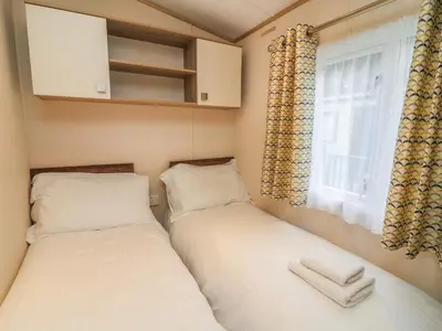 two beds in a small room with a window at 12A Borwick Lakes in Carnforth