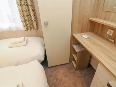 a small room with two beds and a desk at 12A Borwick Lakes in Carnforth