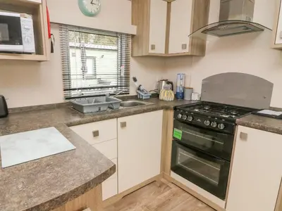 a kitchen with a stove top oven next to a sink at 12A Borwick Lakes in Carnforth