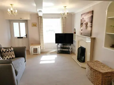 a living room with a couch and a television at Hillside Farm Cottage in Grange Over Sands