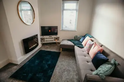a living room with a couch and a fireplace at PARKER St by Prestige Properties SA in Barrow in Furness