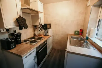 a small kitchen with a stove and a sink at PARKER St by Prestige Properties SA in Barrow in Furness