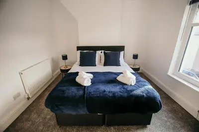 a bedroom with a large bed with towels on it at PARKER St by Prestige Properties SA in Barrow in Furness