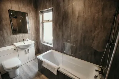 a bathroom with a tub and a sink and a toilet at PARKER St by Prestige Properties SA in Barrow in Furness