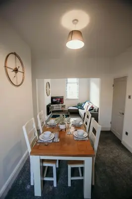 a dining table and chairs in a living room at PARKER St by Prestige Properties SA in Barrow in Furness