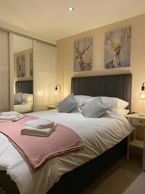a bedroom with a large bed with two towels on it at Sawley in the Forest of Bowland - cosy cottage. in Clitheroe