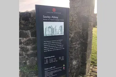 a sign for the sony museum on the side of a wall at Sawley in the Forest of Bowland - cosy cottage. in Clitheroe