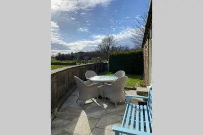 a patio with a table and chairs and a fence at Sawley in the Forest of Bowland - cosy cottage. in Clitheroe