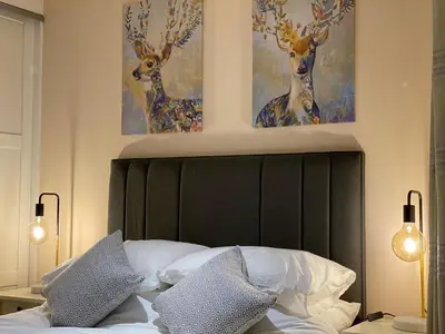 a bedroom with a bed with two deer paintings on the wall at Sawley in the Forest of Bowland - cosy cottage. in Clitheroe