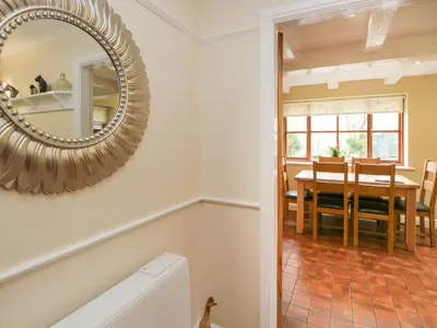 a bathroom with a mirror and a dining room at Laithe Cottage in Ulverston