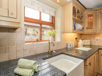 a kitchen with a sink and a window at Laithe Cottage in Ulverston