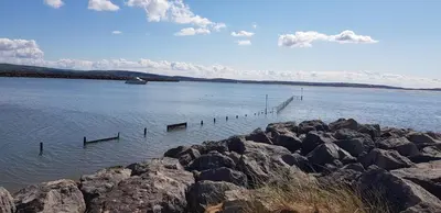 a large body of water with rocks and a boat at Port Haverigg Marina Village in Millom