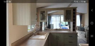 a kitchen with a sink and a mirror at Port Haverigg Marina Village in Millom