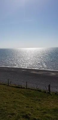 a beach with a fence and the ocean at Port Haverigg Marina Village in Millom