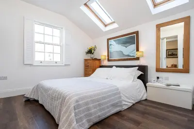 a bedroom with a bed and a mirror and skylights at Finest Retreats - Lighthouse Cottage in Rampside