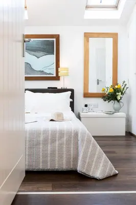 a bedroom with a bed and a mirror at Finest Retreats - Lighthouse Cottage in Rampside