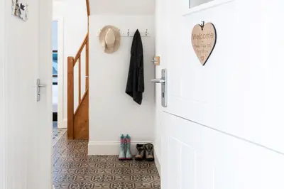 a hallway with a white door and a tile floor at Finest Retreats - Lighthouse Cottage in Rampside