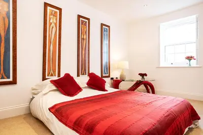 a bedroom with a large bed with red pillows at Finest Retreats - Lighthouse Cottage in Rampside
