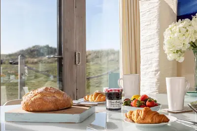 a table with a loaf of bread and a plate of fruit at Finest Retreats - The Lighthouse Hide in Rampside