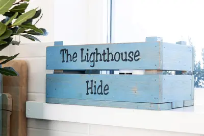 a stack of blue crates with the bright house hide at Finest Retreats - The Lighthouse Hide in Rampside