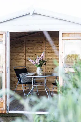 a patio with a table and a vase of flowers at Finest Retreats - The Lighthouse Hide in Rampside
