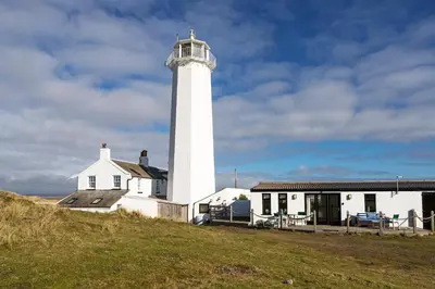 a lighthouse on a hill next to a house at Finest Retreats - Walney Island Lighthouse in Rampside