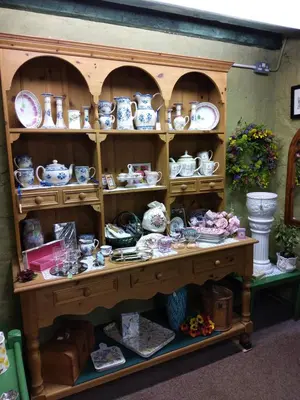 a shelf full of pottery on a table at Lile Cottage at Gleaston Water Mill in Ulverston