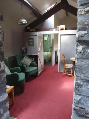 a living room with a couch and a dog on the ceiling at Lile Cottage at Gleaston Water Mill in Ulverston