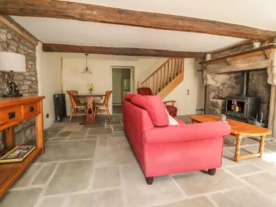 a living room with a red chair and a table at Sunny Bank in Lancaster