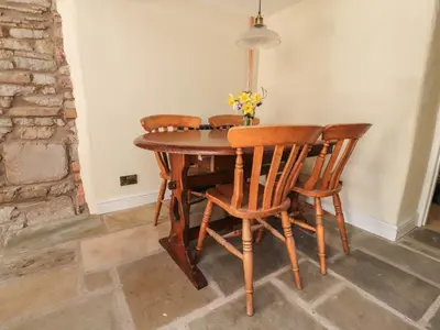 a dining room table with four chairs and a lamp at Sunny Bank in Lancaster