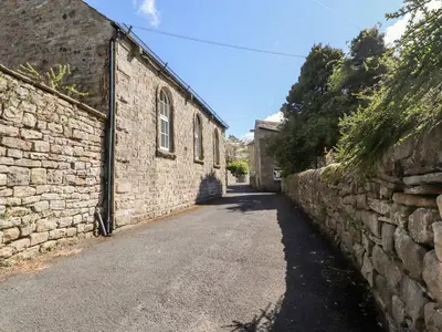 an alley with a stone wall next to a building at Sunny Bank in Lancaster