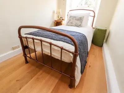 a bed in a room with a wooden floor at Sunny Bank in Lancaster