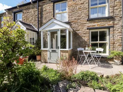 a house with a white door and a table and chairs at Sunny Bank in Lancaster